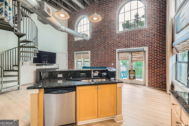 791 Wylie St SE Unit 410, Atlanta, GA 30316 - kitchen featuring stainless steel dishwasher, a sink, brick wall, a high ceiling, and light wood-type flooring