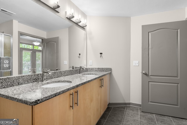 full bath with double vanity, visible vents, tile patterned flooring, and a sink
