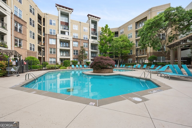 pool with a patio and fence