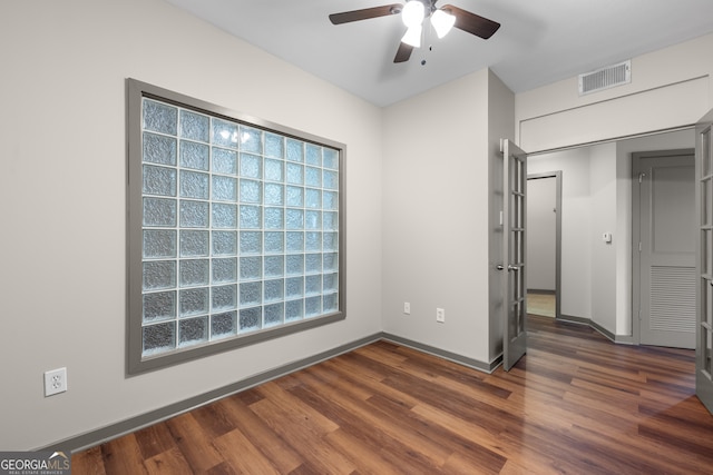 unfurnished bedroom with ceiling fan, baseboards, dark wood-type flooring, and visible vents