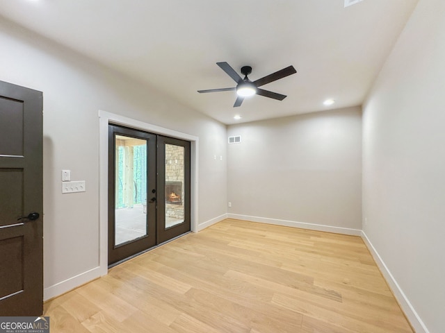unfurnished room featuring baseboards, french doors, a ceiling fan, and light wood-style floors