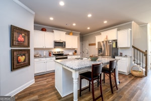 kitchen featuring a center island with sink, ornamental molding, recessed lighting, and appliances with stainless steel finishes