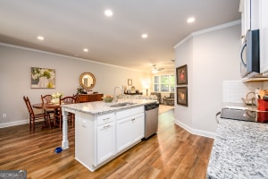 kitchen with a sink, ornamental molding, stainless steel appliances, and white cabinets