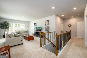 living area featuring light carpet, baseboards, and recessed lighting