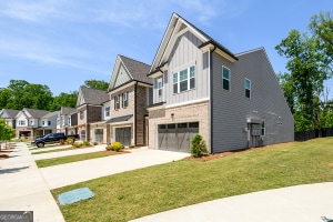 view of side of property with a lawn, board and batten siding, driveway, a garage, and a residential view