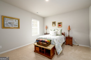 bedroom featuring baseboards and light colored carpet