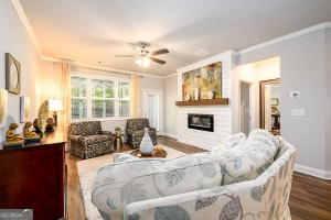 living area featuring crown molding, a large fireplace, and wood finished floors