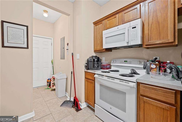2171 Wilson Ave NW, Atlanta, GA 30314 - kitchen with light tile patterned floors, brown cabinets, baseboards, white appliances, and light countertops