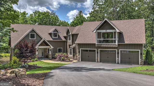 craftsman house featuring aphalt driveway, an attached garage, a shingled roof, and stone siding