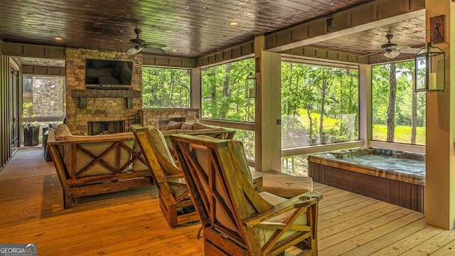 sunroom / solarium with a fireplace and ceiling fan