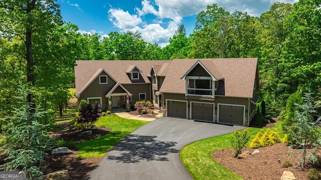 craftsman-style home with an attached garage, stone siding, aphalt driveway, board and batten siding, and roof with shingles
