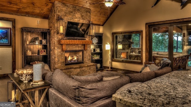 interior space with a ceiling fan, baseboards, wood ceiling, high vaulted ceiling, and a fireplace