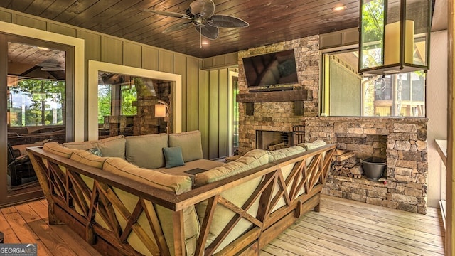exterior space featuring a ceiling fan, a healthy amount of sunlight, wood-type flooring, and wood ceiling