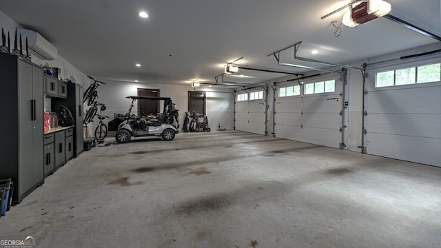 garage with recessed lighting, a wall mounted AC, and a garage door opener