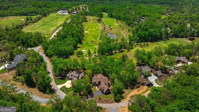 drone / aerial view featuring a residential view, golf course view, and a wooded view