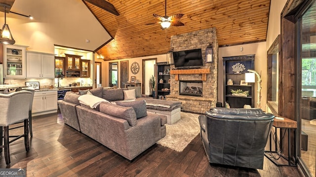 living area featuring a ceiling fan, a stone fireplace, high vaulted ceiling, and wooden ceiling