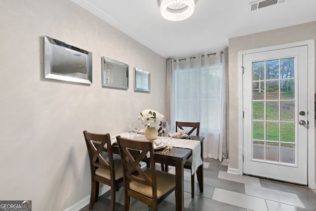 dining area featuring baseboards, a notable chandelier, ornamental molding, and visible vents