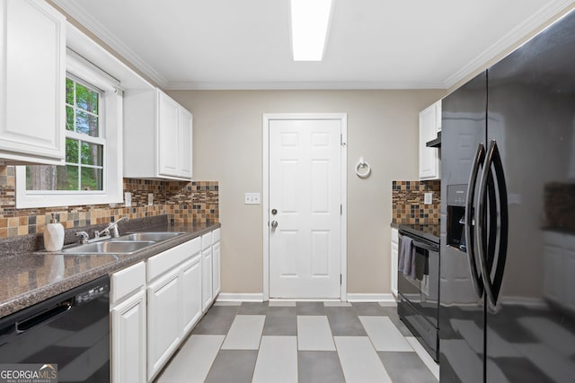 kitchen with dark countertops, white cabinetry, black appliances, and a sink