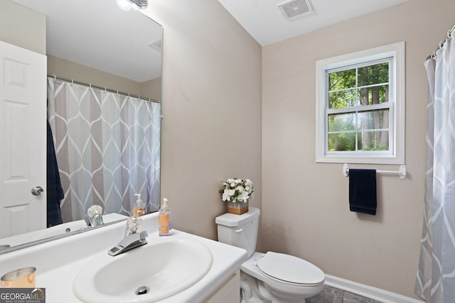 full bath featuring vanity, toilet, baseboards, and visible vents