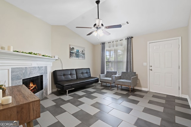 living room with a ceiling fan, a tile fireplace, baseboards, and lofted ceiling