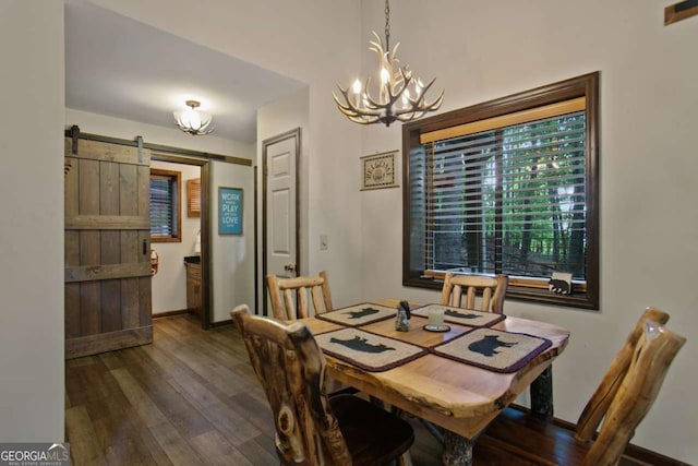 dining room featuring an inviting chandelier, wood finished floors, a barn door, and baseboards
