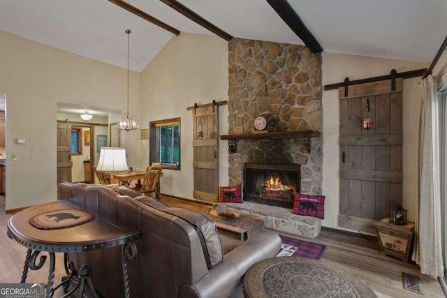 living room featuring wood finished floors, a barn door, high vaulted ceiling, a chandelier, and beamed ceiling