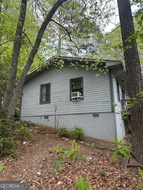 view of home's exterior featuring cooling unit and crawl space