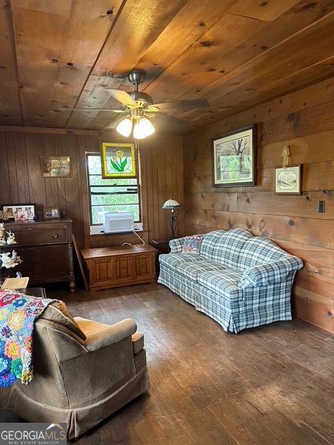 interior space with ceiling fan, wooden walls, wood ceiling, and wood-type flooring
