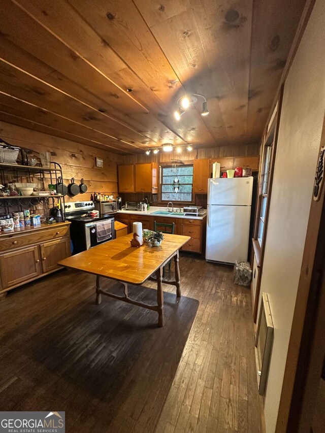 kitchen featuring a sink, freestanding refrigerator, dark wood-style flooring, stainless steel electric range oven, and wood ceiling