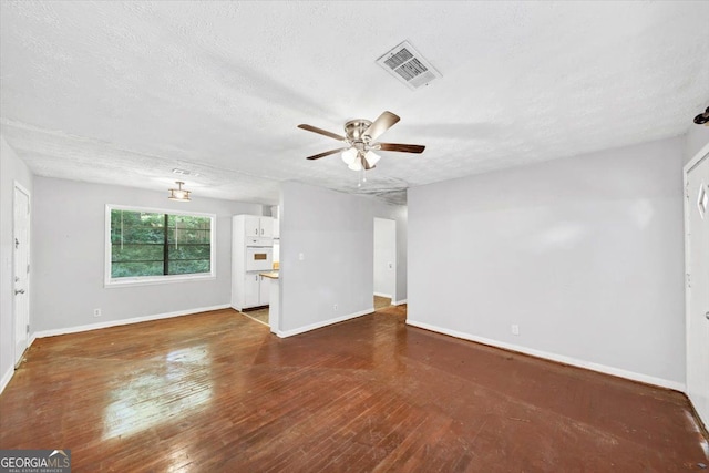 844 Oak St NW, Atlanta, GA 30318 - unfurnished living room with hardwood / wood-style flooring, a textured ceiling, visible vents, a ceiling fan, and baseboards