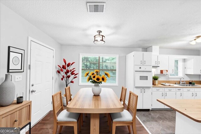 844 Oak St NW, Atlanta, GA 30318 - dining area featuring a textured ceiling, dark wood-type flooring, and visible vents