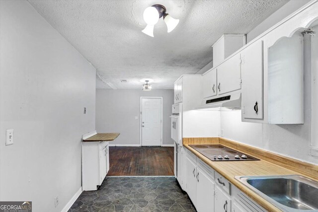 844 Oak St NW, Atlanta, GA 30318 - kitchen featuring black electric cooktop, a textured ceiling, a sink, and white cabinets