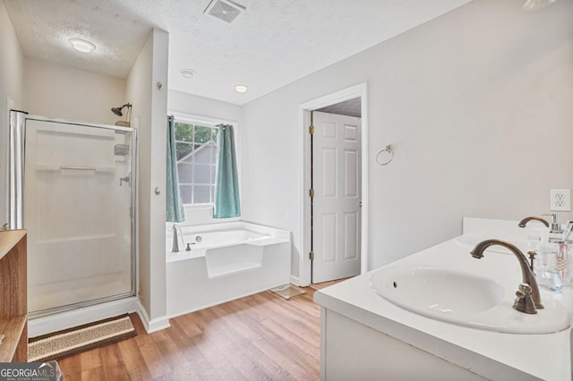 1314 Durham Ter, Mcdonough, GA 30252 - full bathroom with a shower stall, wood finished floors, a bath, double vanity, and a textured ceiling