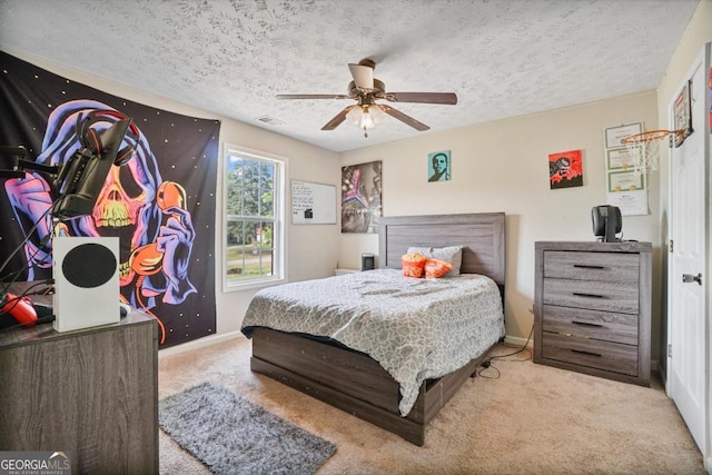 bedroom with carpet flooring, a textured ceiling, visible vents, baseboards, and ceiling fan
