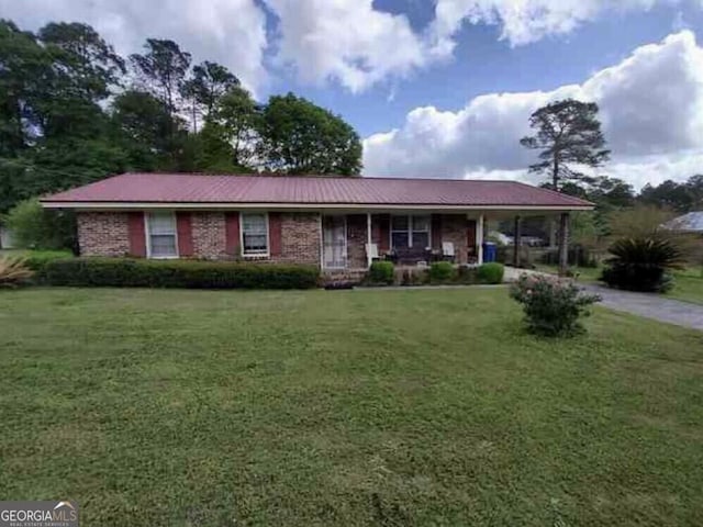 single story home with covered porch, driveway, and a front lawn