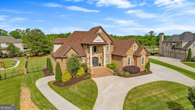 770 Tralee Dr, Fayetteville, GA 30215 - view of front of house with brick siding, curved driveway, fence, a shingled roof, and a front lawn
