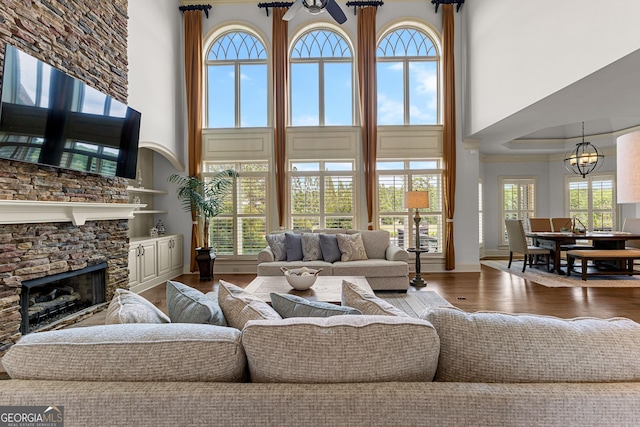 770 Tralee Dr, Fayetteville, GA 30215 - living room featuring a fireplace, an inviting chandelier, a towering ceiling, and wood finished floors