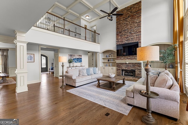 770 Tralee Dr, Fayetteville, GA 30215 - living area with wood finished floors, a towering ceiling, ornate columns, ceiling fan, and a stone fireplace