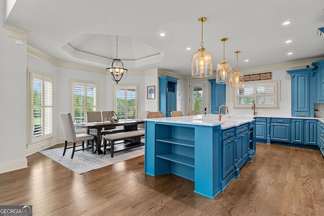 770 Tralee Dr, Fayetteville, GA 30215 - kitchen featuring blue cabinets, ornamental molding, open shelves, a kitchen island with sink, and a notable chandelier