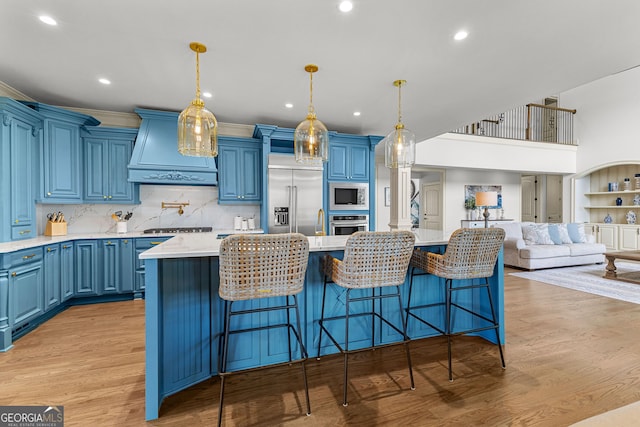 770 Tralee Dr, Fayetteville, GA 30215 - kitchen with built in appliances, custom exhaust hood, light wood-style flooring, and blue cabinets