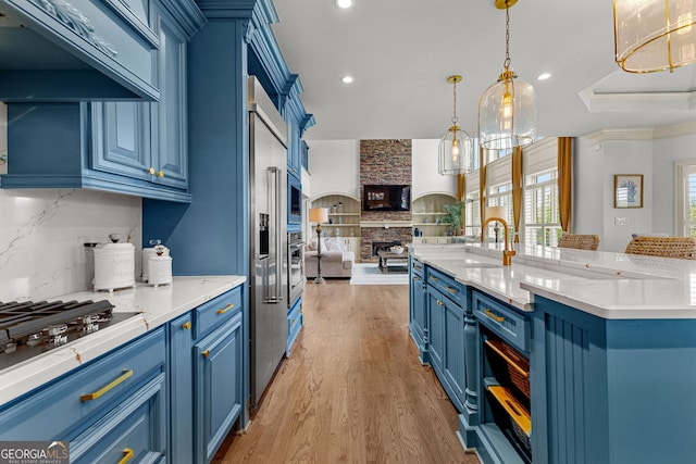 770 Tralee Dr, Fayetteville, GA 30215 - kitchen featuring exhaust hood, tasteful backsplash, blue cabinets, light wood-style flooring, and open floor plan