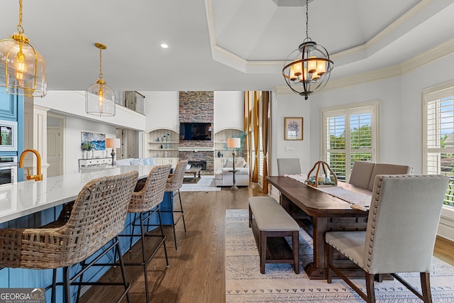 770 Tralee Dr, Fayetteville, GA 30215 - dining area featuring an inviting chandelier, wood finished floors, a fireplace, crown molding, and recessed lighting