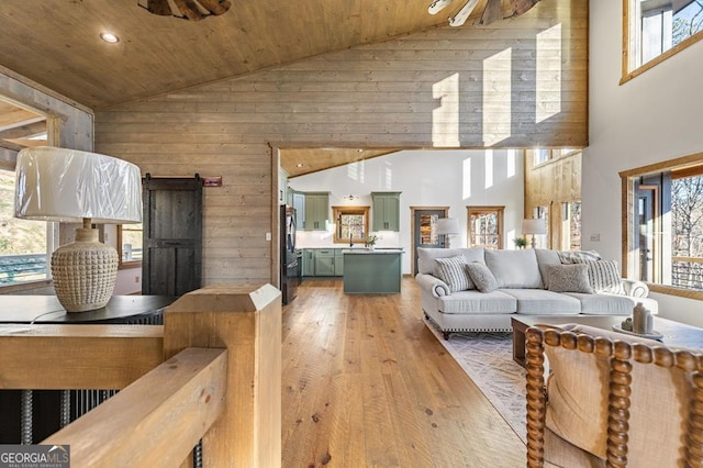 living room featuring wooden walls, light wood-style flooring, high vaulted ceiling, and wooden ceiling