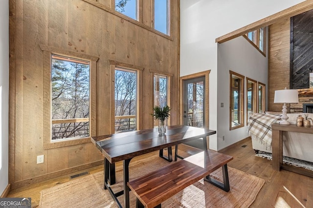 dining space with plenty of natural light, visible vents, and a high ceiling