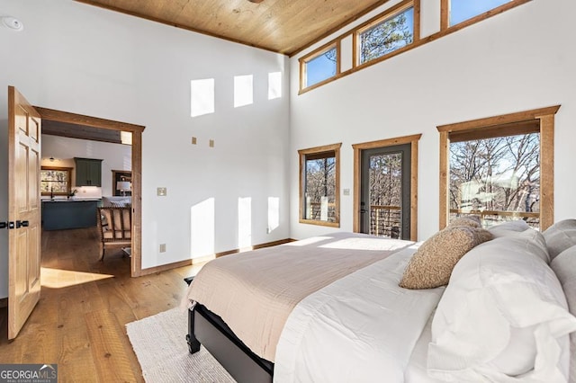 bedroom with light wood-style flooring, wood ceiling, access to outside, and multiple windows