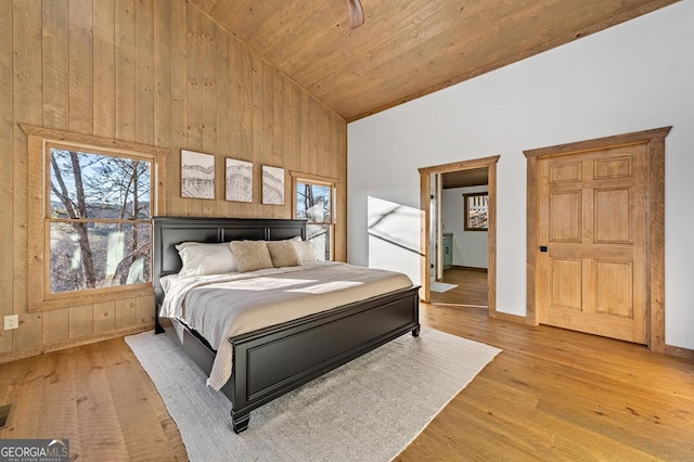 bedroom featuring light wood-style flooring, high vaulted ceiling, and multiple windows