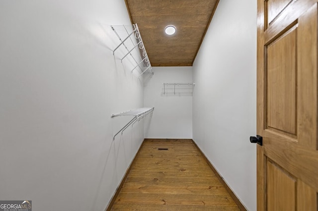 walk in closet with wood finished floors