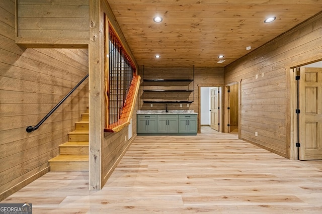 interior space featuring recessed lighting, wooden walls, and a sink