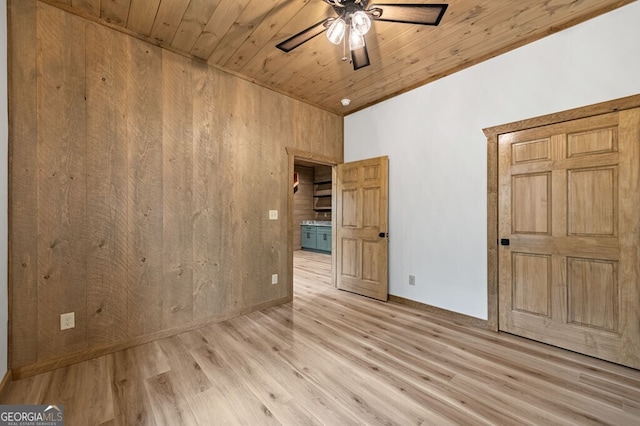 unfurnished bedroom featuring baseboards, ceiling fan, light wood-type flooring, and wooden ceiling