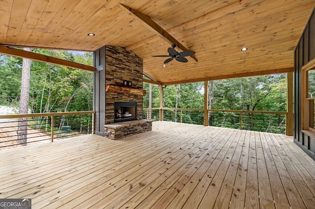 wooden terrace featuring an outdoor stone fireplace and ceiling fan